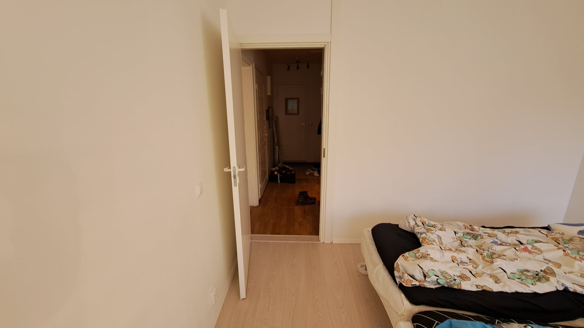 Remontoitu huone, siistit seinäpinnat, oviaukko ja lattia.