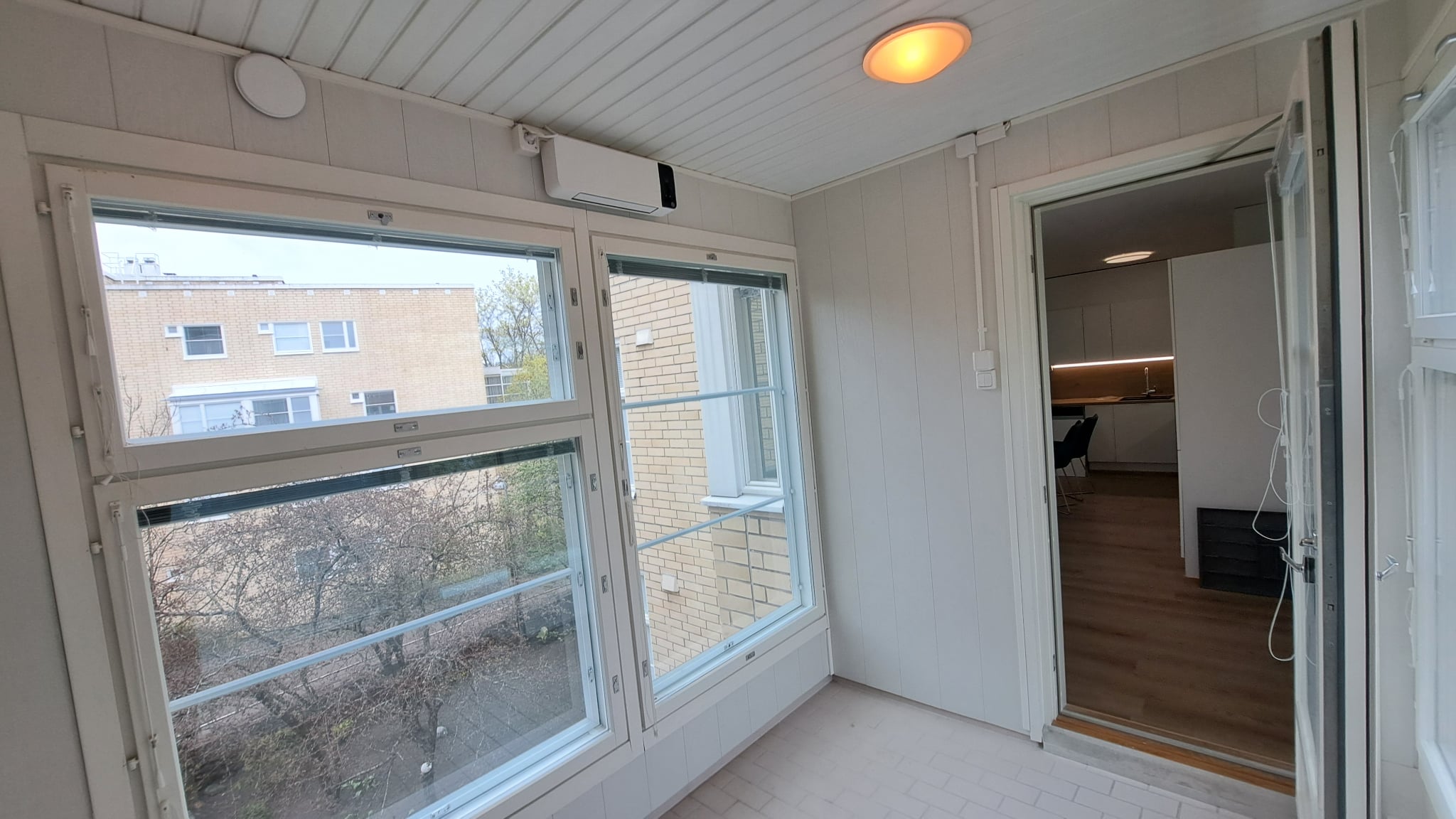 Remontoitu huone Helsingissä, jossa on suuret ikkunat, valkoiset ikkunanpuitteet ja siistit sisäpinnat.