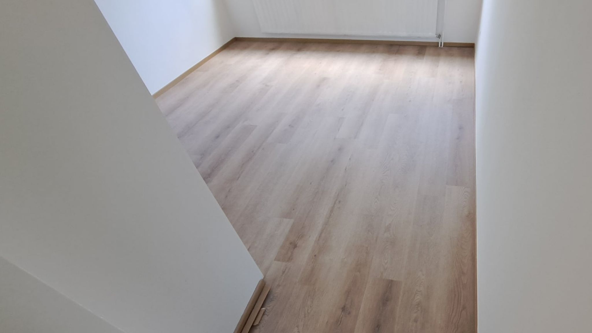 Kylpyhuoneremontti Helsingissä, jossa on moderni allaskaappi, suihku ja tummat lattialaatat.