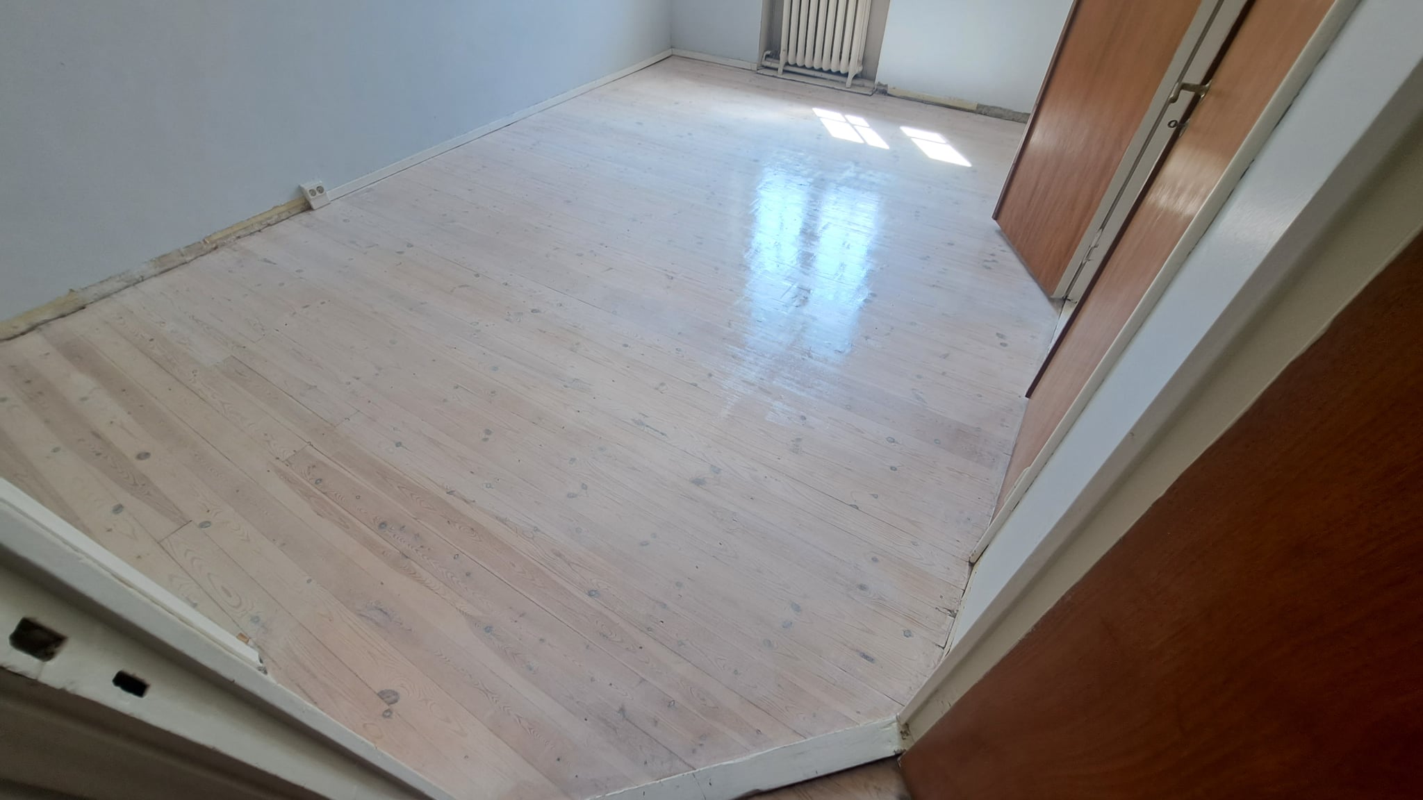 Vaalea puunsävyinen lattia asennettuna huoneistoon Mannerheimintiellä Helsingissä.