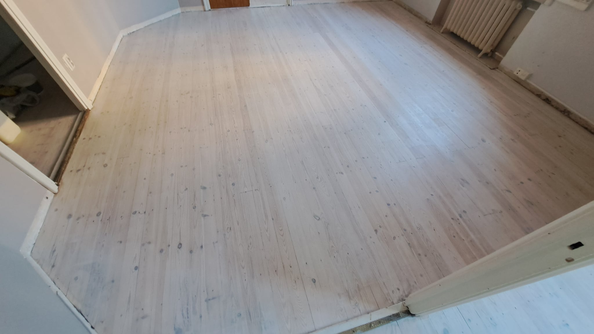 Lattiaremontin lopputulos Helsingissä, jossa on vaalea puulattia ja siistit sisäpinnat.